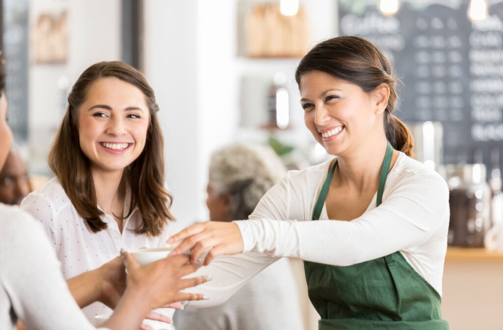 Three individuals in a coffee shop shaking hands with each other - Brainy millions